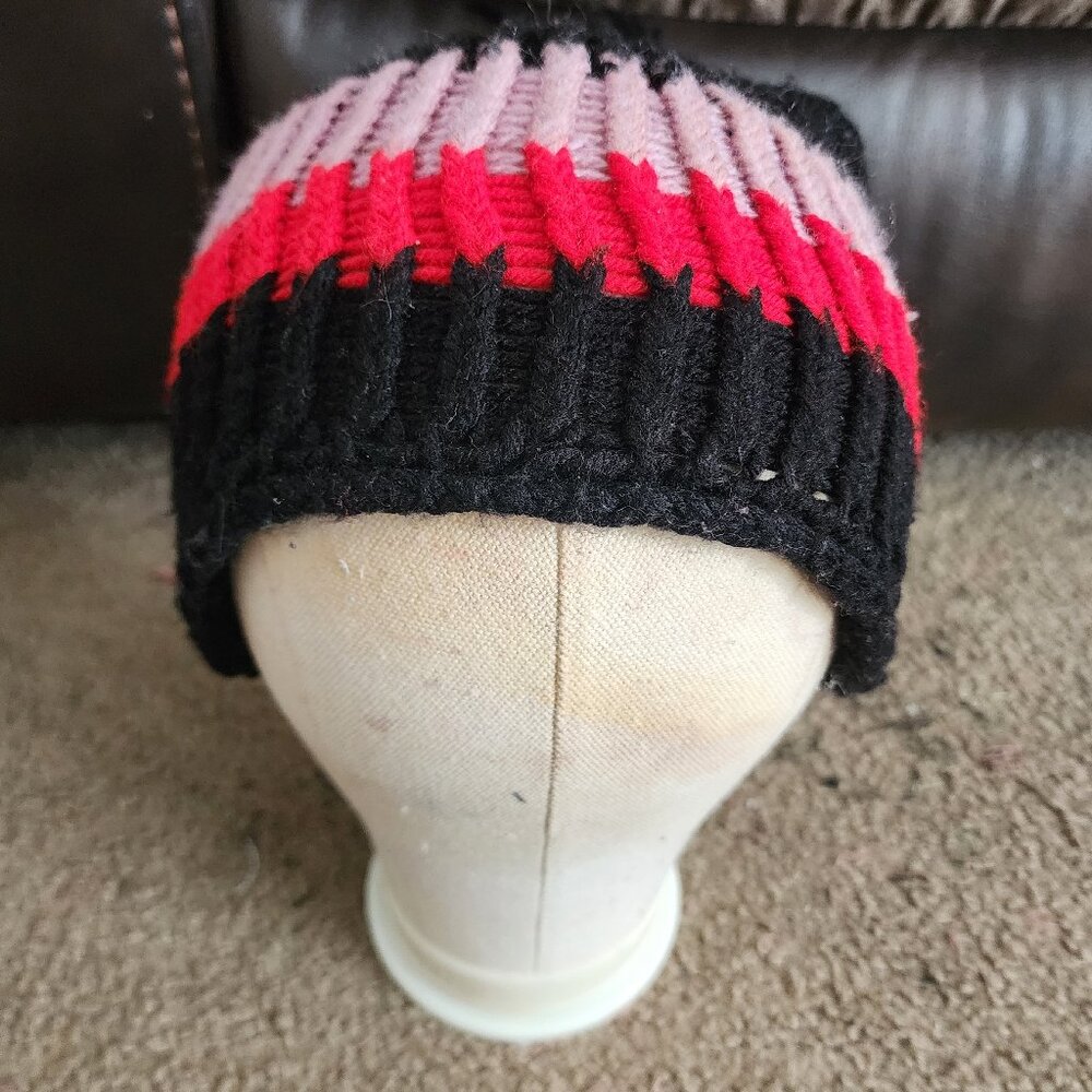 A custom handmade black, purple and red pom pom knitted hat